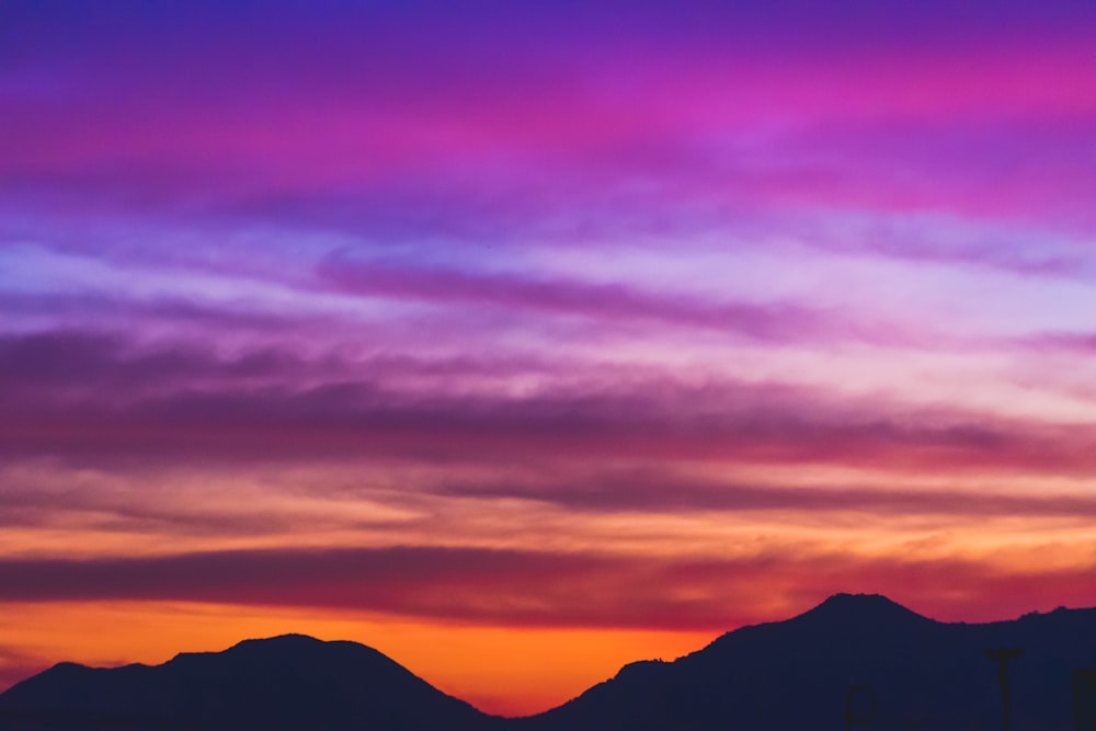 a colorful sky with mountains in the background