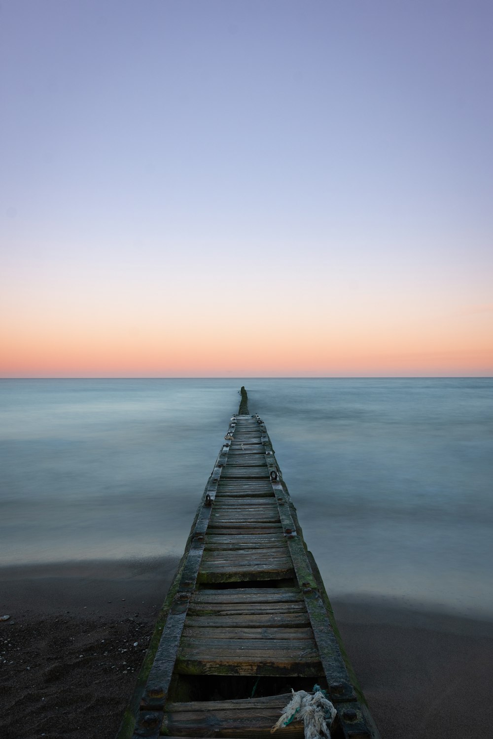 a long wooden pier stretching out into the ocean