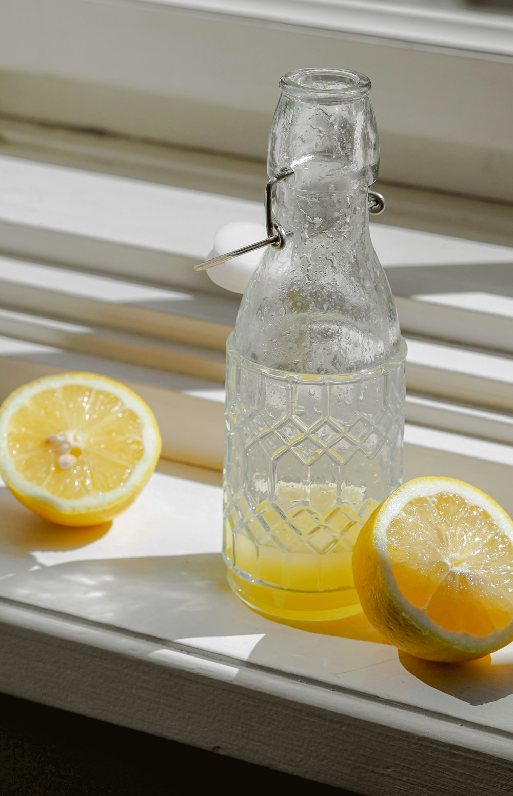 a bottle of lemonade sitting on a window sill