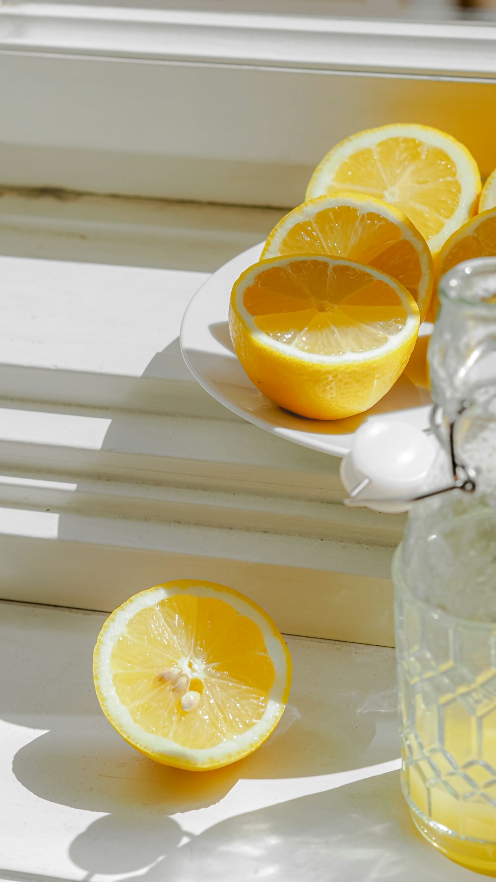 a plate of lemons sitting on a window sill