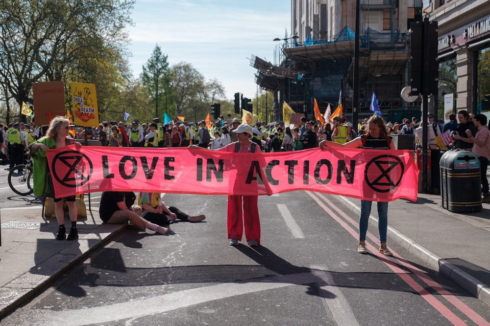 a group of people holding a pink protest sign