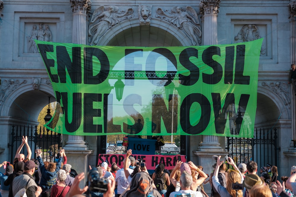 a group of people holding up a green sign