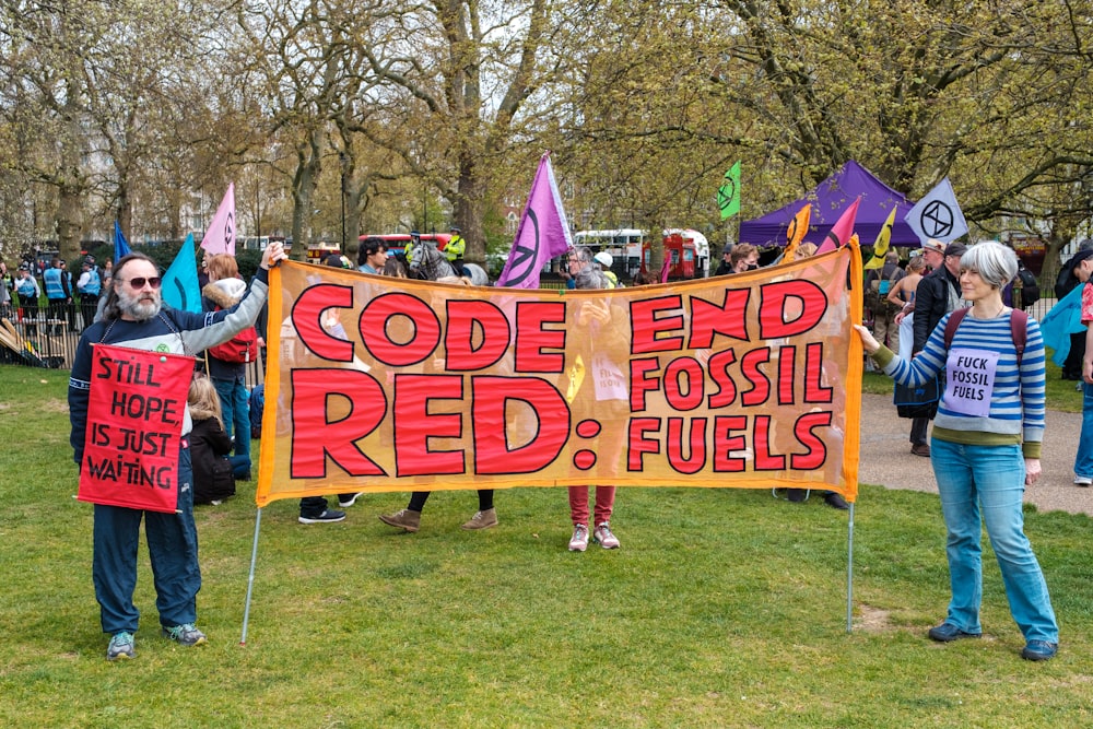 a group of people holding a sign that says code end fossil fuels
