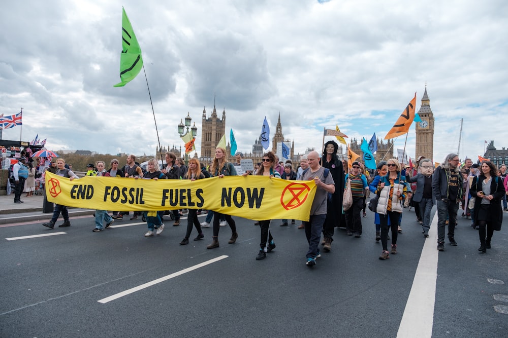 a group of people walking down a street holding a banner