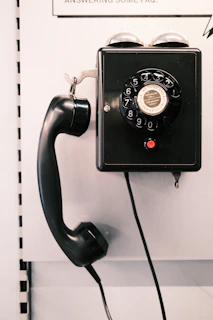 an old fashioned telephone is hanging on a wall