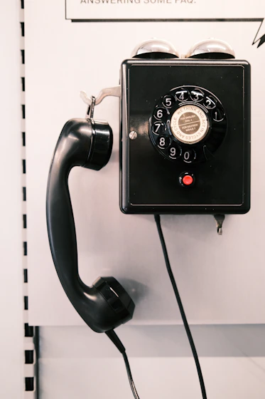 an old fashioned telephone is hanging on a wall