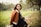 a woman sitting on a bench in a park
