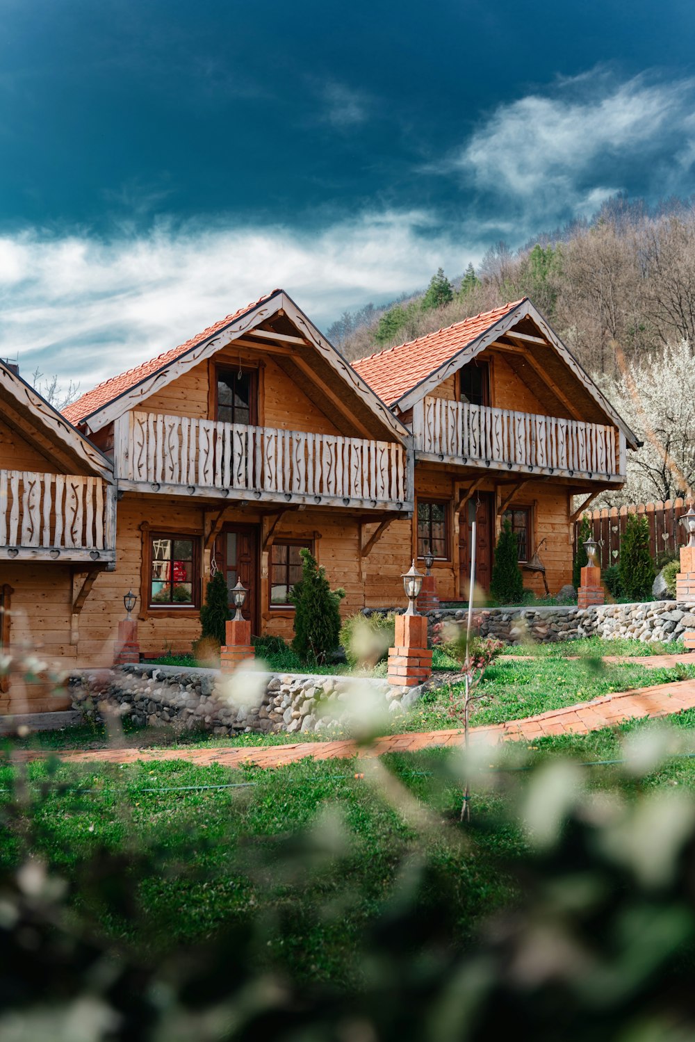 a couple of wooden houses sitting on top of a lush green field