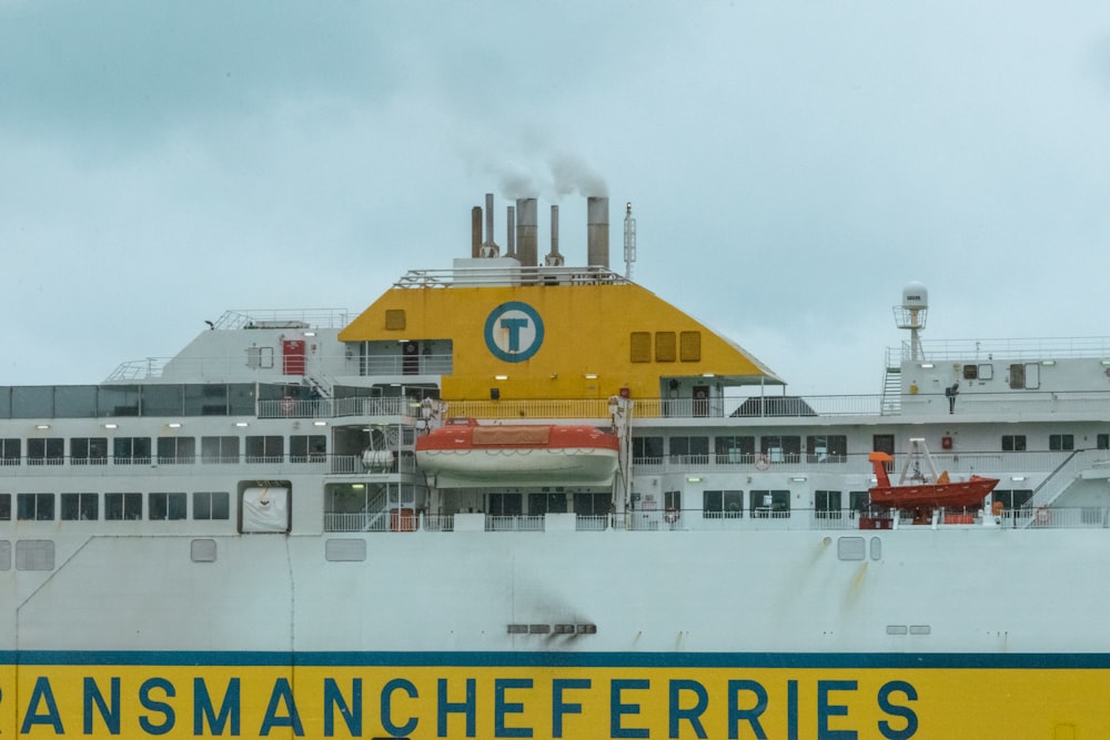 a large white ship with a yellow and green sign on it's side