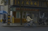 A Lumina hoodie draped over a bicycle parked near a bustling café.