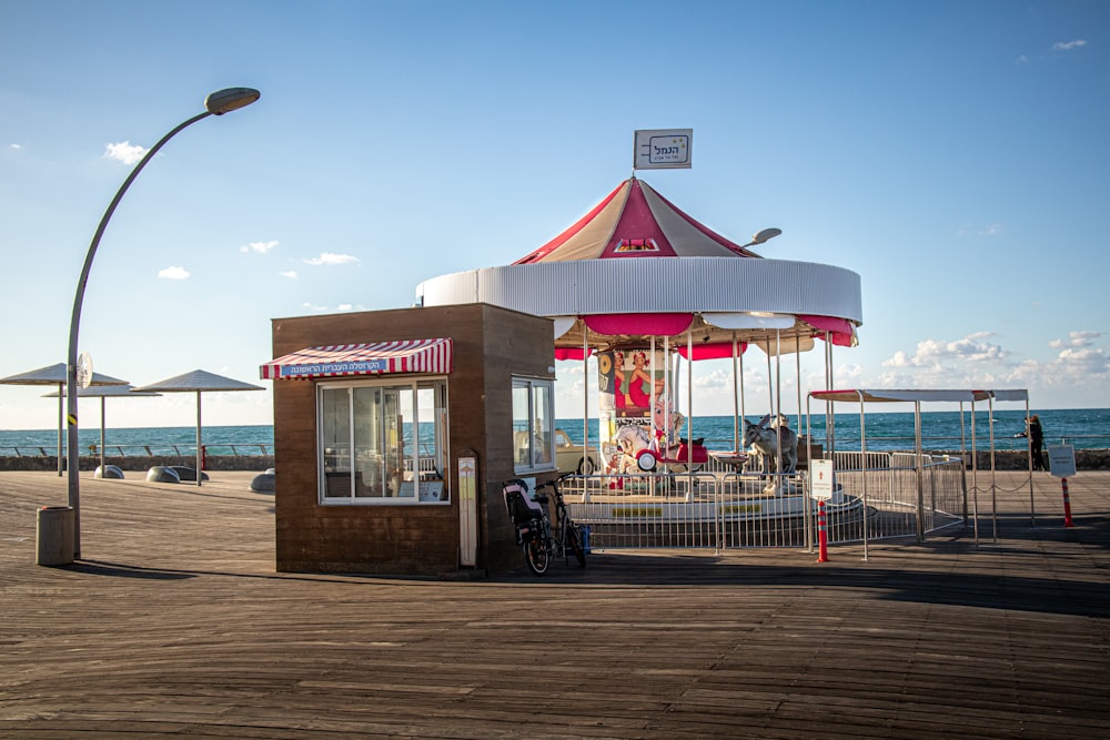 a carousel on a boardwalk next to the ocean