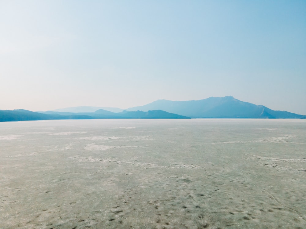 a vast expanse of water with mountains in the distance