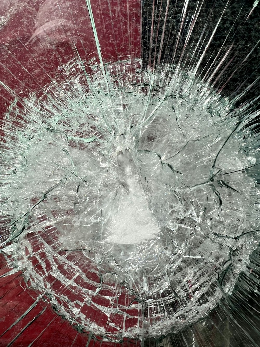 a broken glass window with a red background