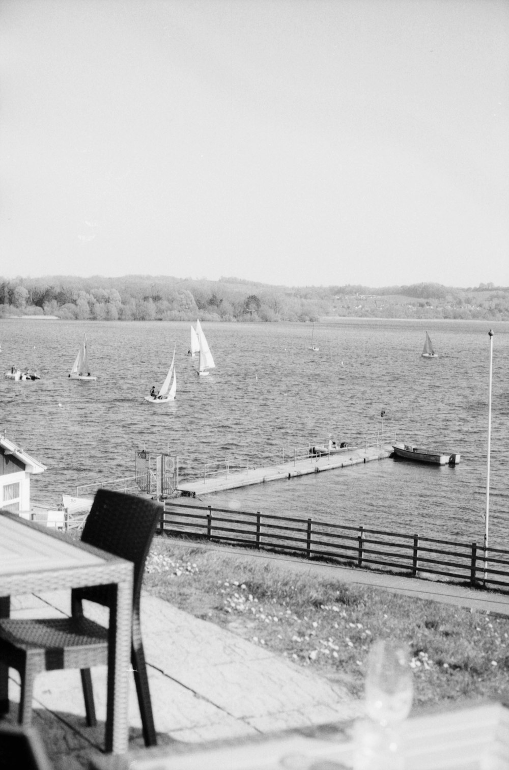 a black and white photo of a lake with sailboats
