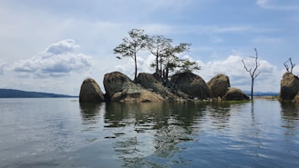 a group of rocks sitting in the middle of a lake