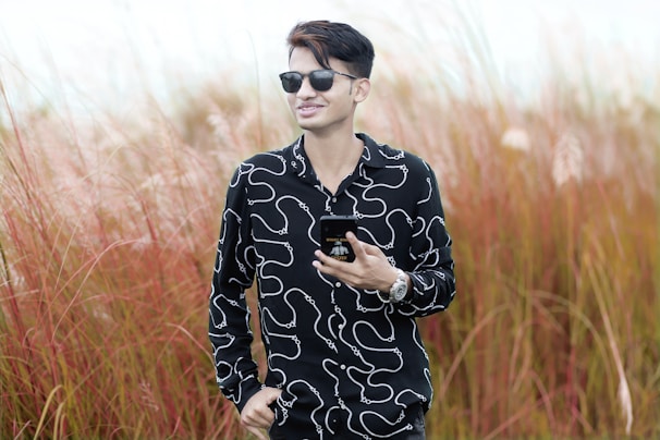 A farmer using a smartphone in a lush green field, smiling while checking farm data on WhatsApp.