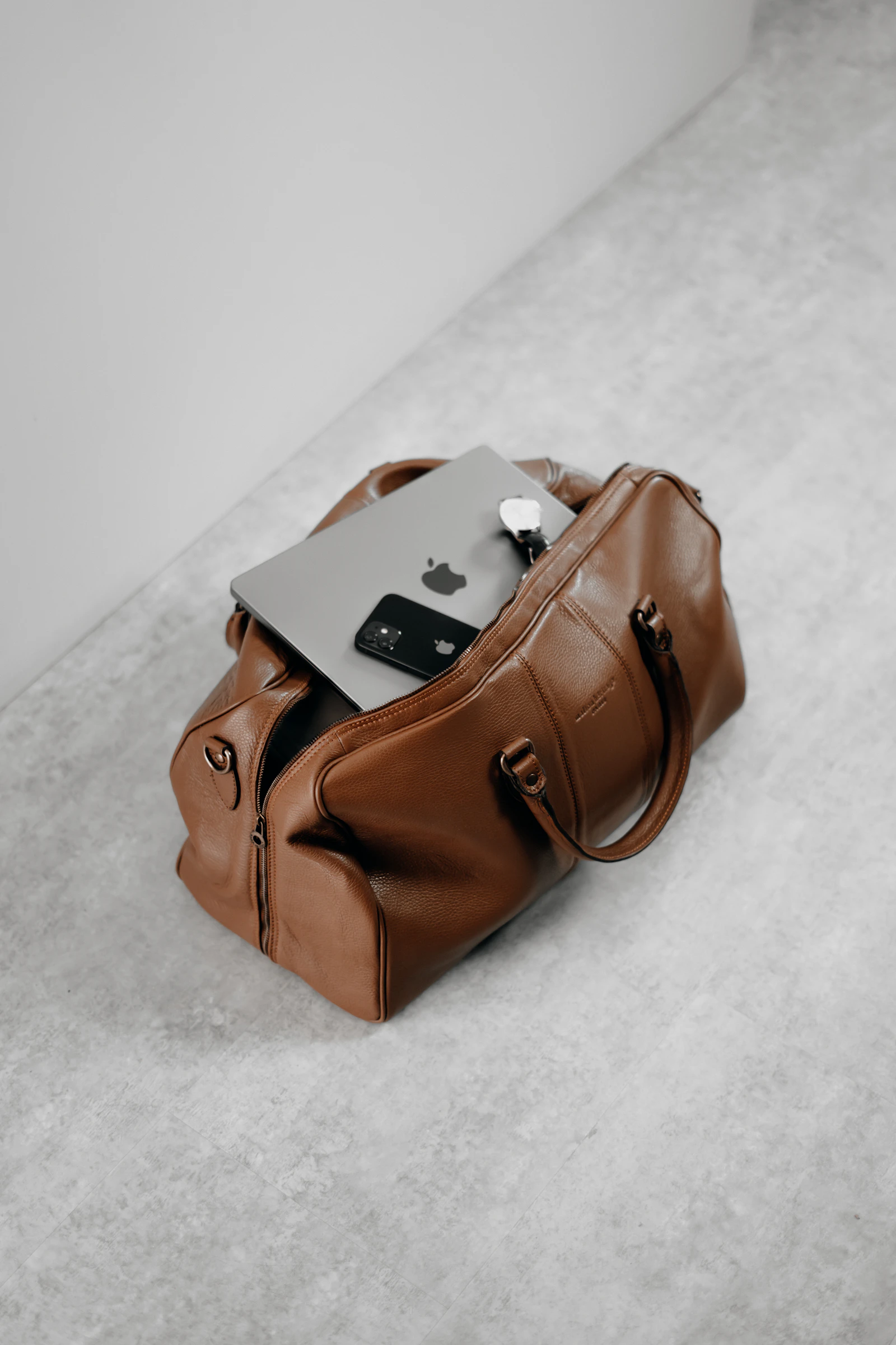 Trousse en cuir brun posée sur un sol clair