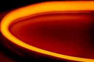 Abstract motion design animation screenshot blending black background with glowing orange strokes.