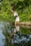 A serene image of a person reflecting by a calm lake.