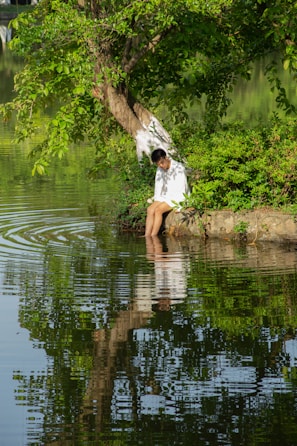 A peaceful scene of a person reflecting by a lake.