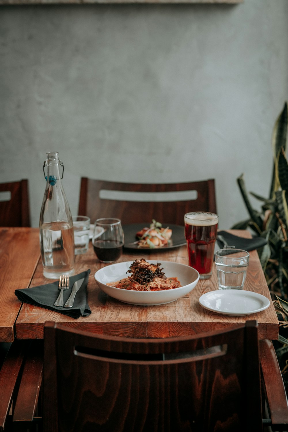 a wooden table topped with a bowl of food