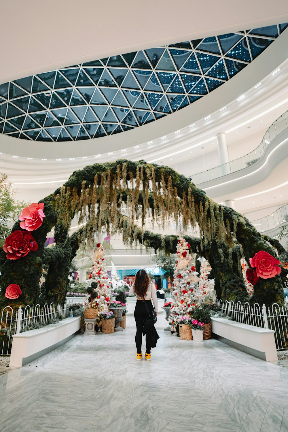 a woman standing in front of a christmas tree