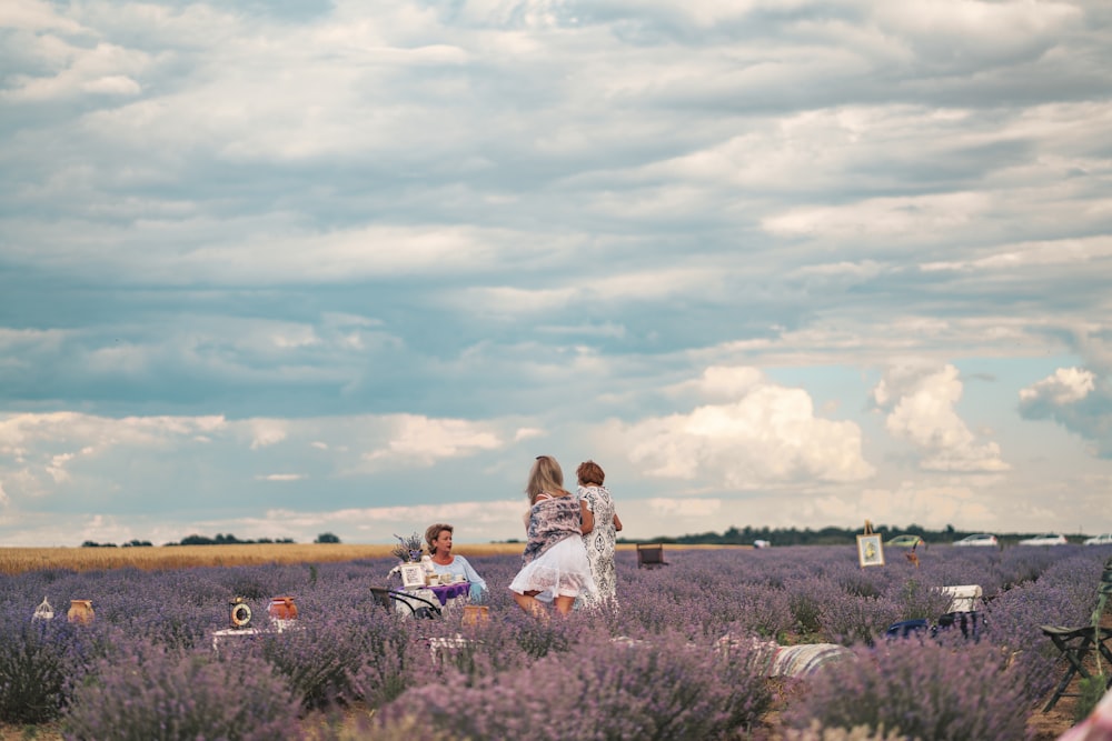 a group of people standing in a field of lavender