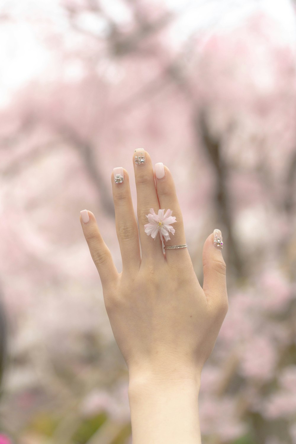 a woman's hand with a flower ring on it