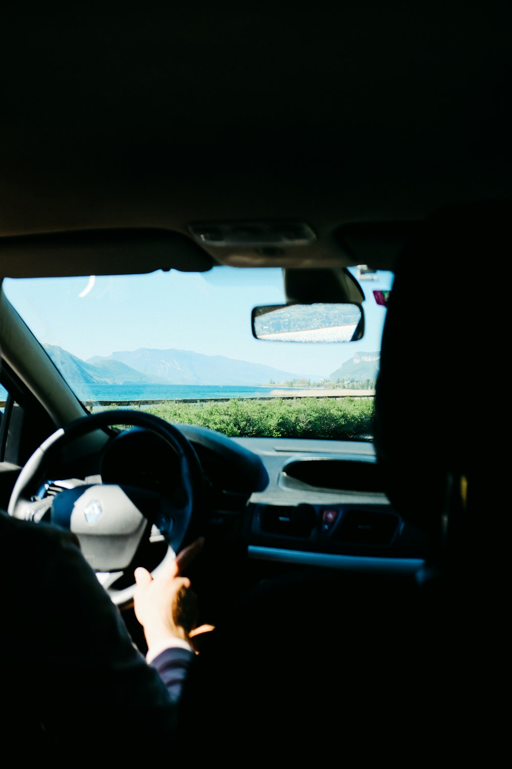 a person driving a car with mountains in the background