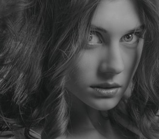 Close-up of a young black woman with long, glossy human hair styled in soft waves