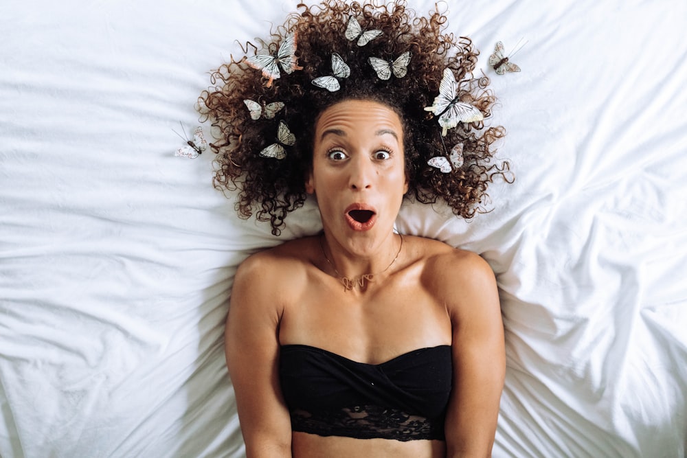 a woman laying in bed with a surprised look on her face