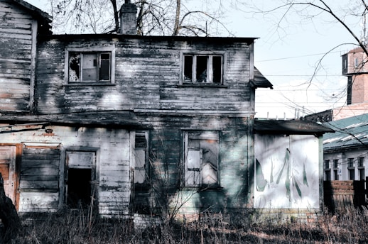 an old run down house with a clock tower