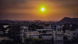 A vibrant sunset over a bustling city skyline with mountains in the background.
