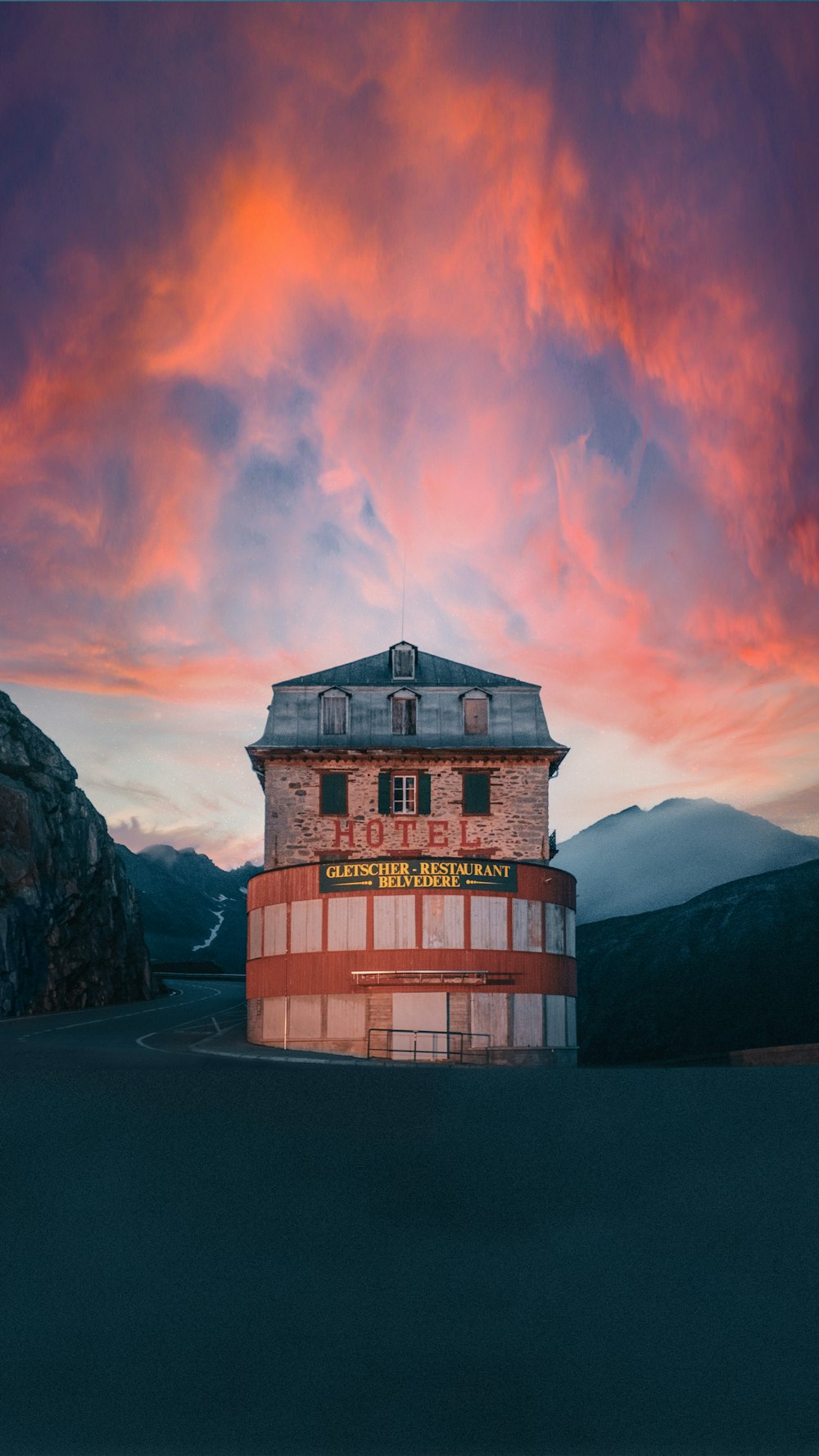 a red and white building sitting in the middle of a mountain