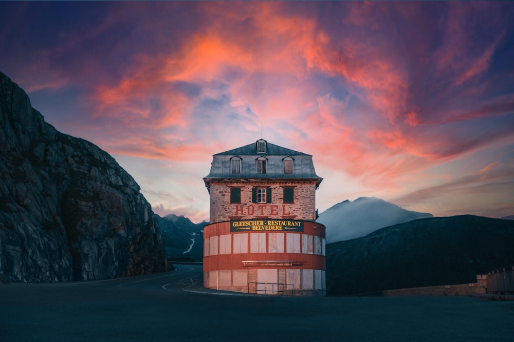 a red and white building sitting in the middle of a mountain