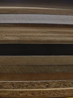 Stacks of polished hardwood furniture pieces sourced from Indonesian craftsmen.