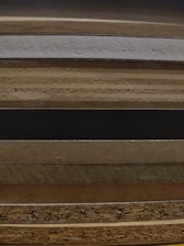Stack of natural wood veneer sheets neatly arranged on a wooden table.