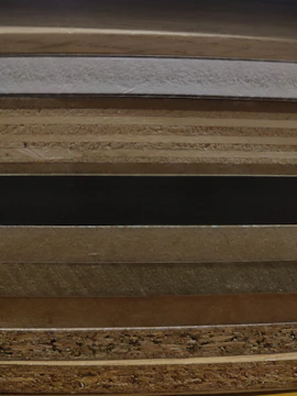 Stack of rich textures including native stones, vibrant tiles, and polished wood samples spread out on a table.