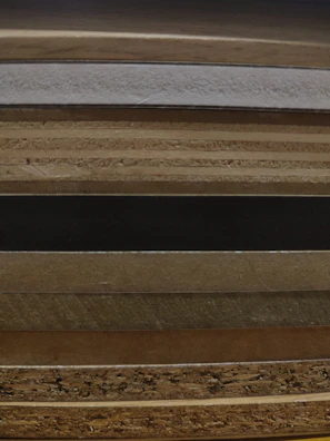 Stacks of polished hardwood furniture pieces sourced from Indonesian craftsmen.