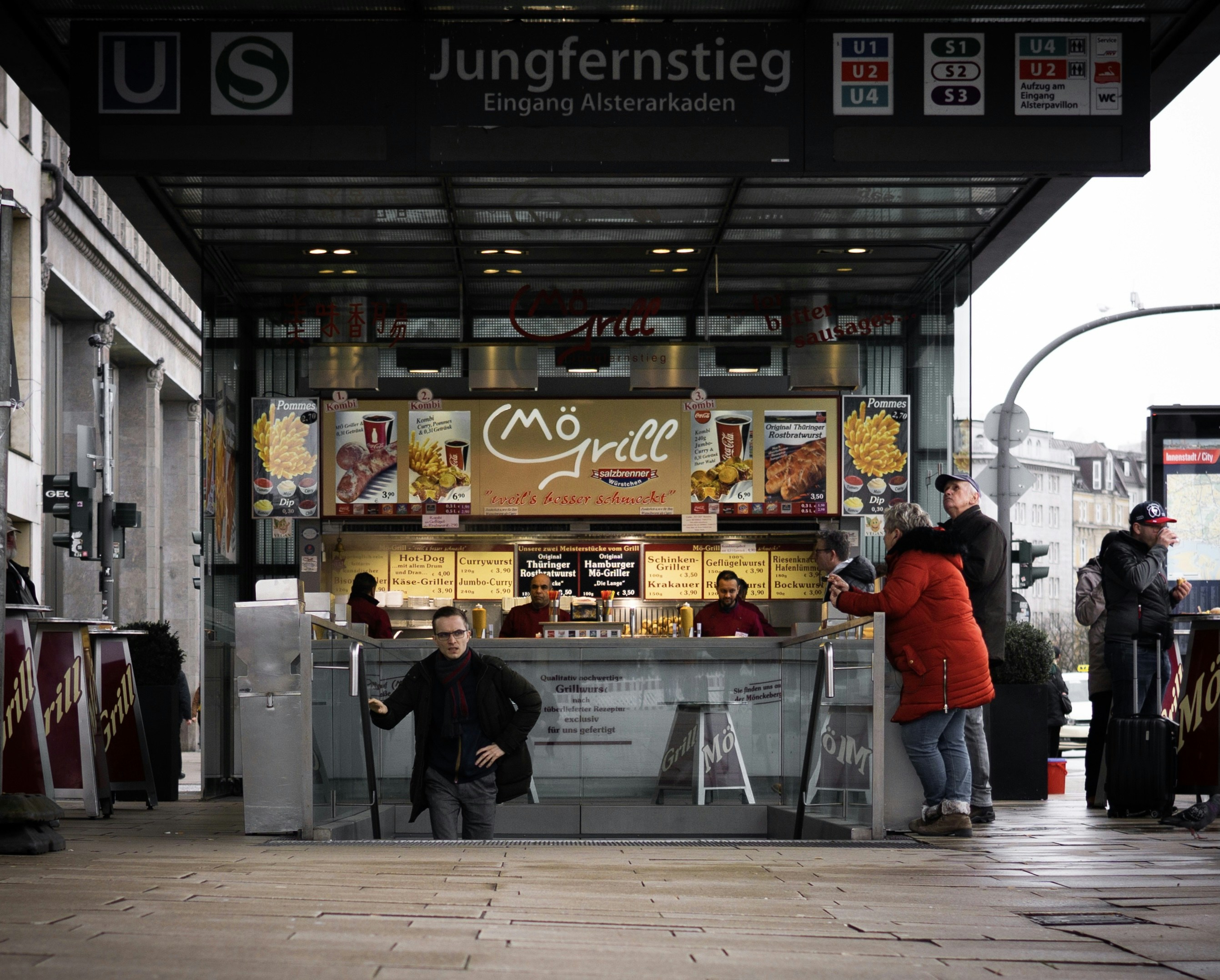 a group of people standing around a food stand