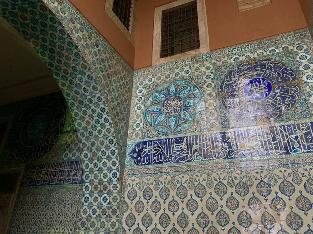 a decorative wall with blue and white tiles