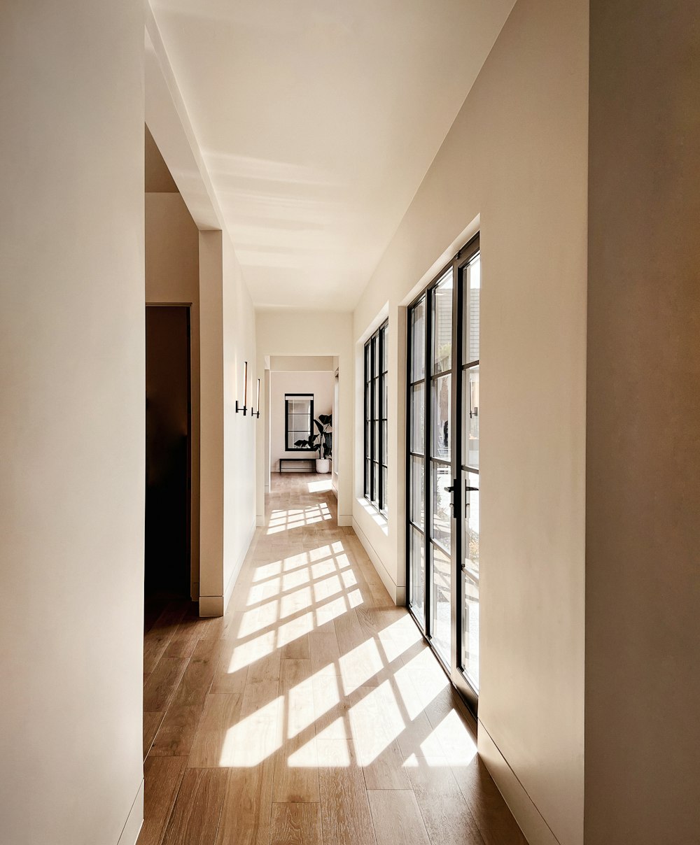 a long hallway with large windows and wooden floors