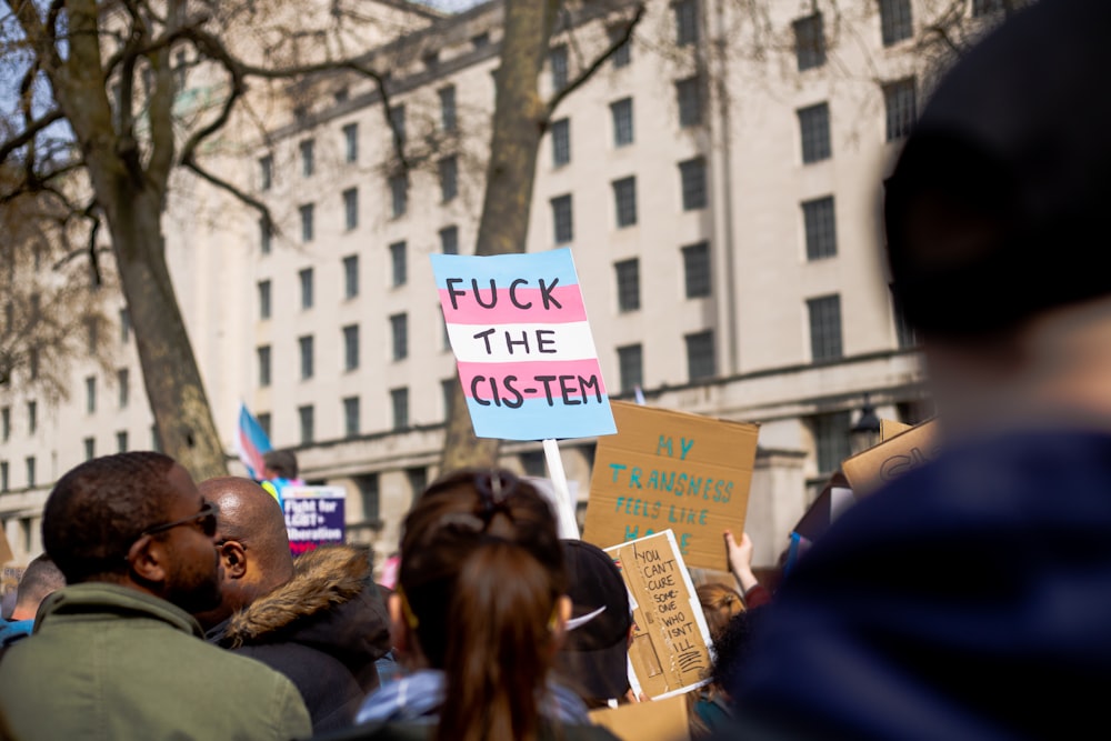 a group of people holding signs in front of a building