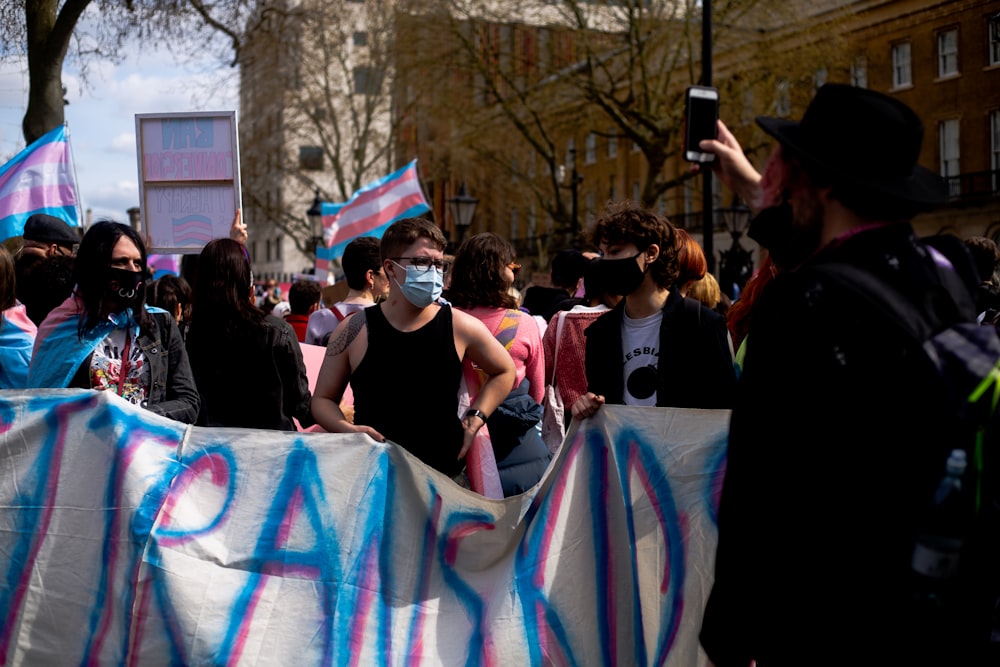 un groupe de personnes tenant des pancartes et portant des masques faciaux