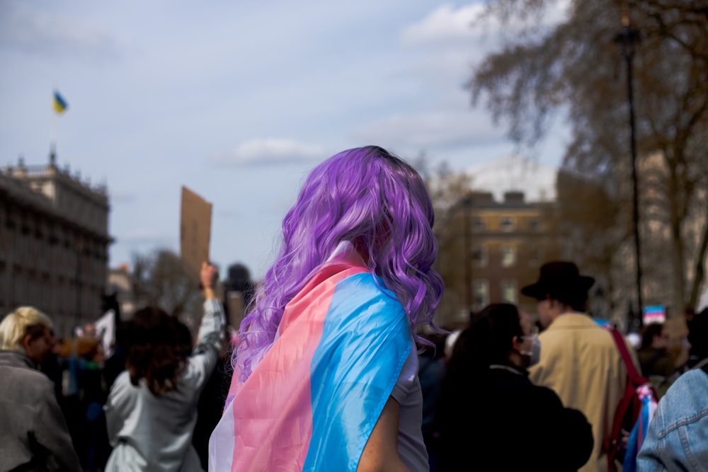 a woman with purple hair is standing in a crowd