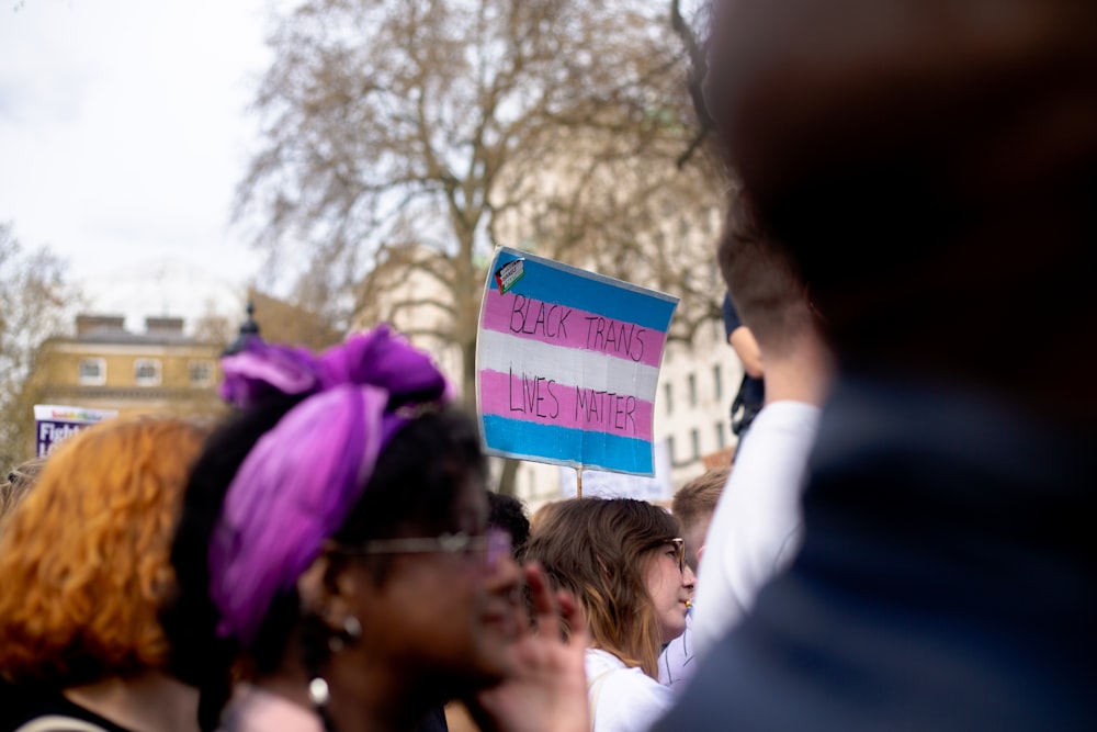 a group of people standing around each other holding a sign