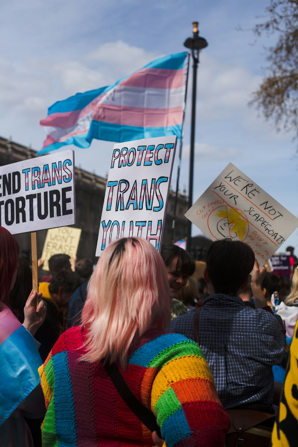 a group of people holding signs in front of a building