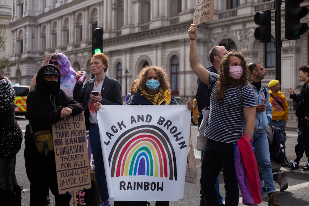 a group of people standing on a street holding signs