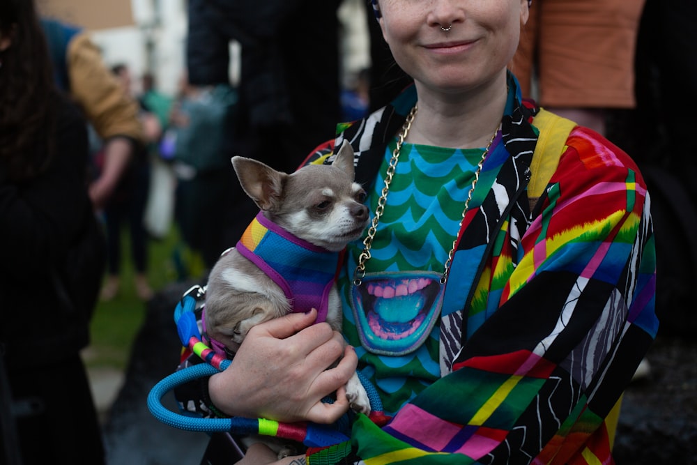 a woman holding a small dog in her arms