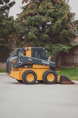 a yellow and black skid steer parked in a parking lot